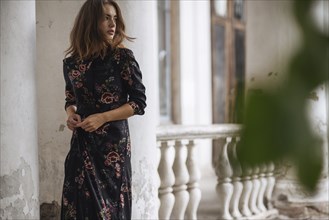 Pensive Caucasian woman standing near pillar