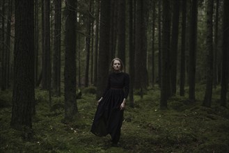 Caucasian woman standing in dark forest
