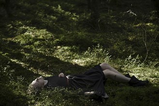 Shadows on Caucasian woman laying in grass