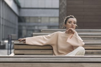 Portrait of pensive Caucasian woman sitting on urban bench