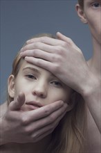 Hands of Caucasian man on face of woman