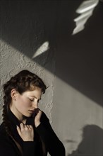 Shadow on wall over pensive Caucasian woman