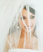 Young bride posing with veiled face