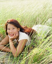 Young woman laying in sea grass