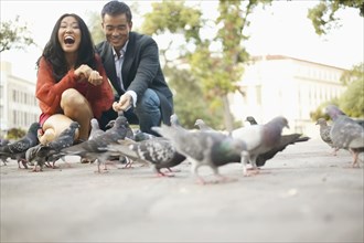 Young couple feeding pigeons