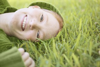 Portrait of a young woman lying on grass