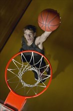 Basketball player about to slam dunk the ball