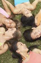 Group of young women lying on the grass