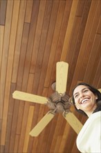 Woman standing under ceiling fan
