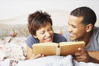 Young couple reading in bed