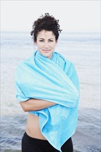 Woman wrapped in towel at beach