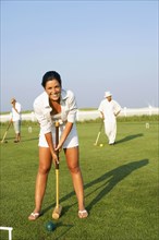 Young woman playing croquet