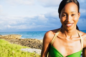 African woman smiling with ocean in background