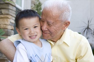 Chinese grandfather hugging grandson