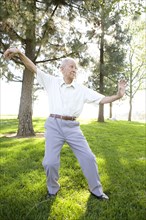 Senior Chinese man doing tai chi outdoors