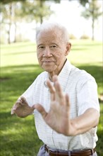 Senior Chinese man doing tai chi outdoors