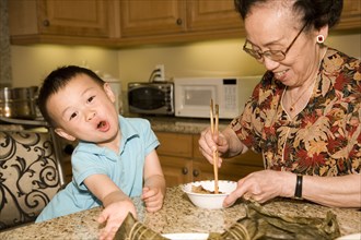 Chinese grandmother feeding grandson