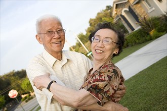 Senior Chinese couple hugging outdoors