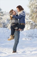 Caucasian couple hugging in snow
