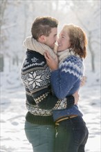Caucasian couple hugging in snow