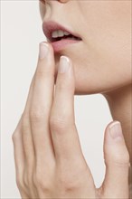 Caucasian woman touching her lip
