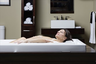 Caucasian woman relaxing in bubble bath