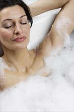 Caucasian woman relaxing in bubble bath