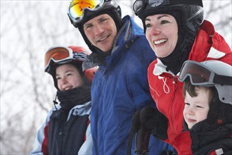 Caucasian family wearing ski gear in snow