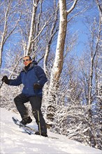 Caucasian man snowshoeing on slope
