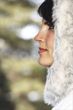 Caucasian woman wearing fur hood in snow