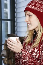 Caucasian woman in winter hat with cup of coffee