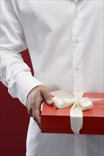 Mixed race man holding wrapped gift