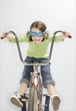 Caucasian girl riding bicycle in goggles