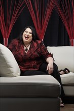 Caucasian woman laughing on sofa