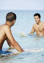 Surfers on surfboard in ocean