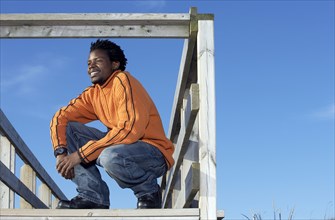 Black man on wooden dock outdoors