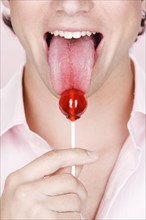 Caucasian man licking lollipop