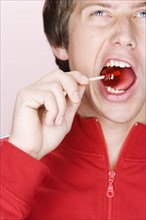 Caucasian man crunching lollipop