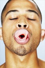Mixed race man popping bubble gum
