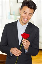 Mixed race businessman holding rose