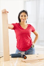 Mixed race woman holding plank of wood