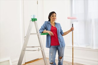 Mixed race woman painting room