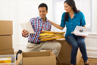 Mixed race couple packing cardboard boxes