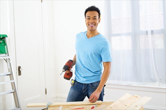 Mixed race carpenter holding power drill