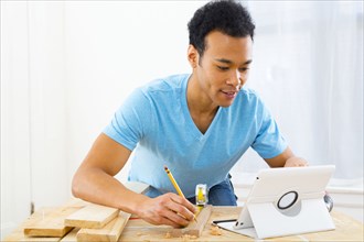 Mixed race carpenter working with digital tablet