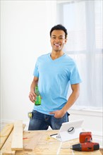 Mixed race carpenter drinking sparkling water