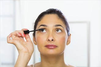 Mixed race woman applying makeup
