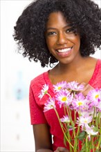 Mixed race woman holding bouquet of flowers
