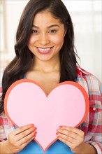 Hispanic woman holding paper heart