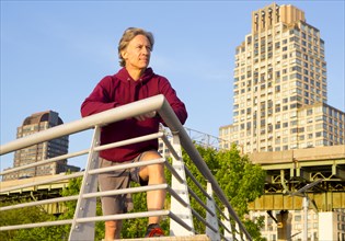 Caucasian man leaning on railing in urban park